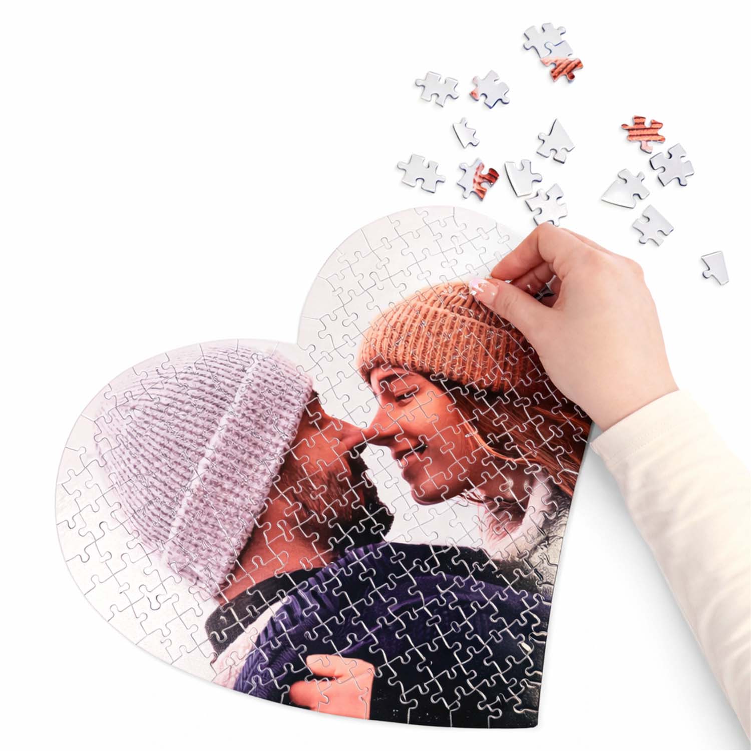 Puzzle a forma di cuore personalizzato con foto, in cartone lucido, con mano che inserisce un pezzo